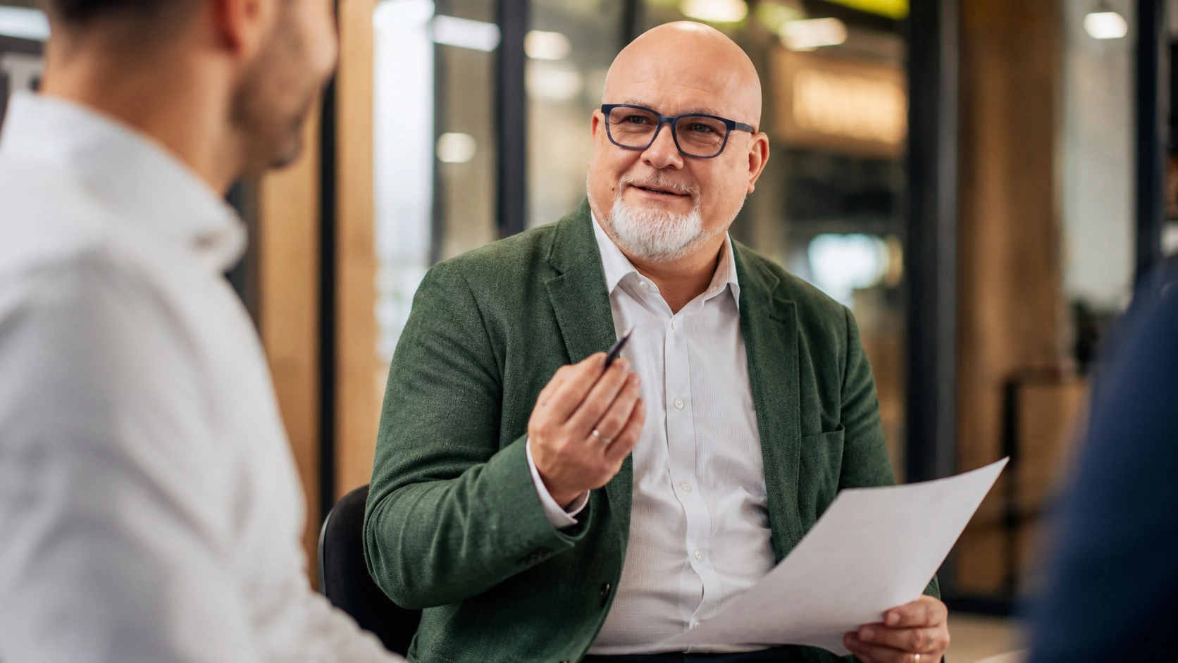 Finanzberater im Erstgespräch erklärt einem Kunden die Unterlagen