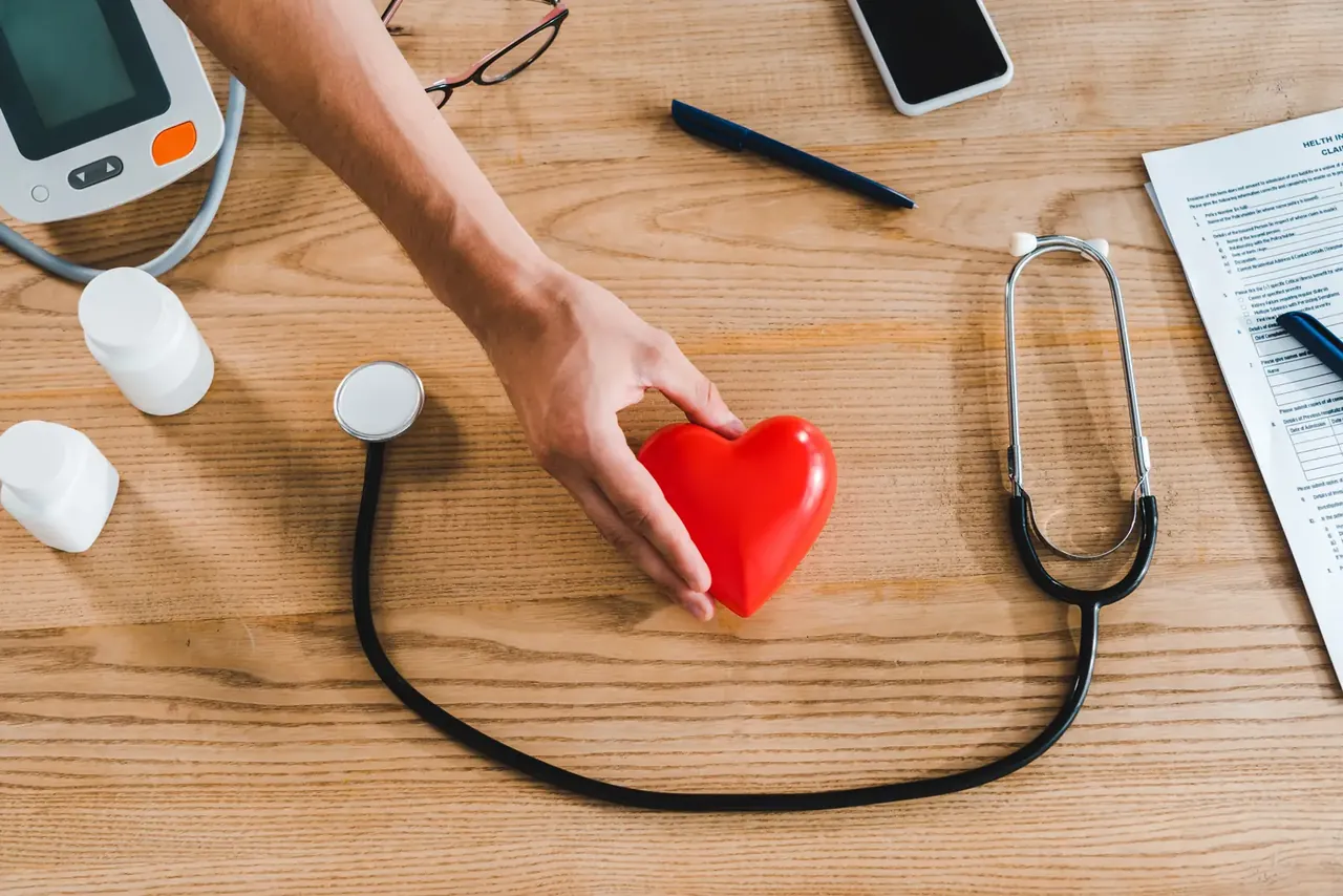 Frau hält ein rotes Herzmodell als Symbol für Gesundheit