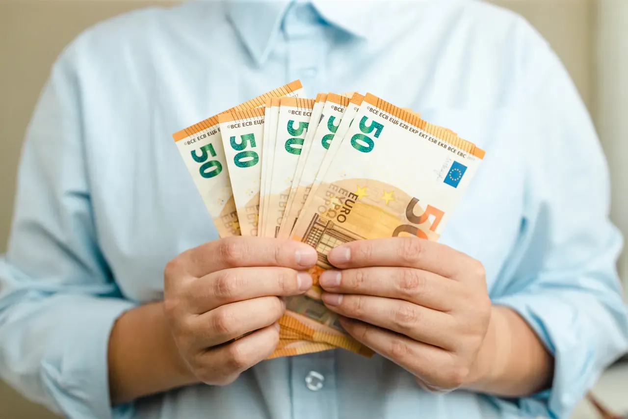Hand hält einen Stapel Fünfzig-Euro-Scheine