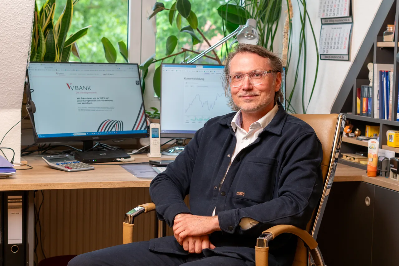 Gunther Hemmann an seinem Arbeitsplatz in Dessau-Roßlau, im Hintergrund Kursverläufe auf dem Bildschirm
