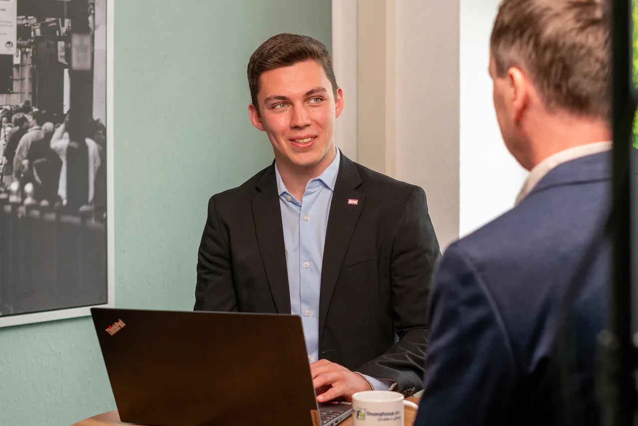 Paskal Eichner erklärt einem Kunden am Laptop die Unterlagen, Standort Altenburg